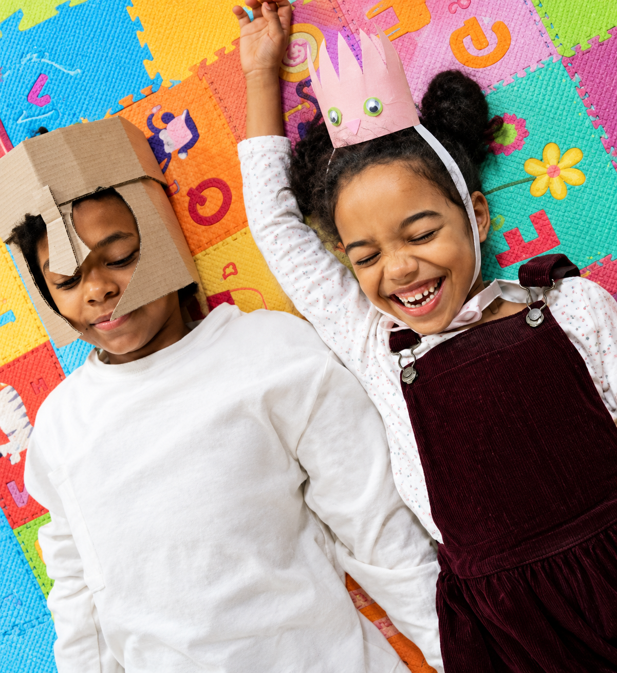 Two young children lying on a colorful foam