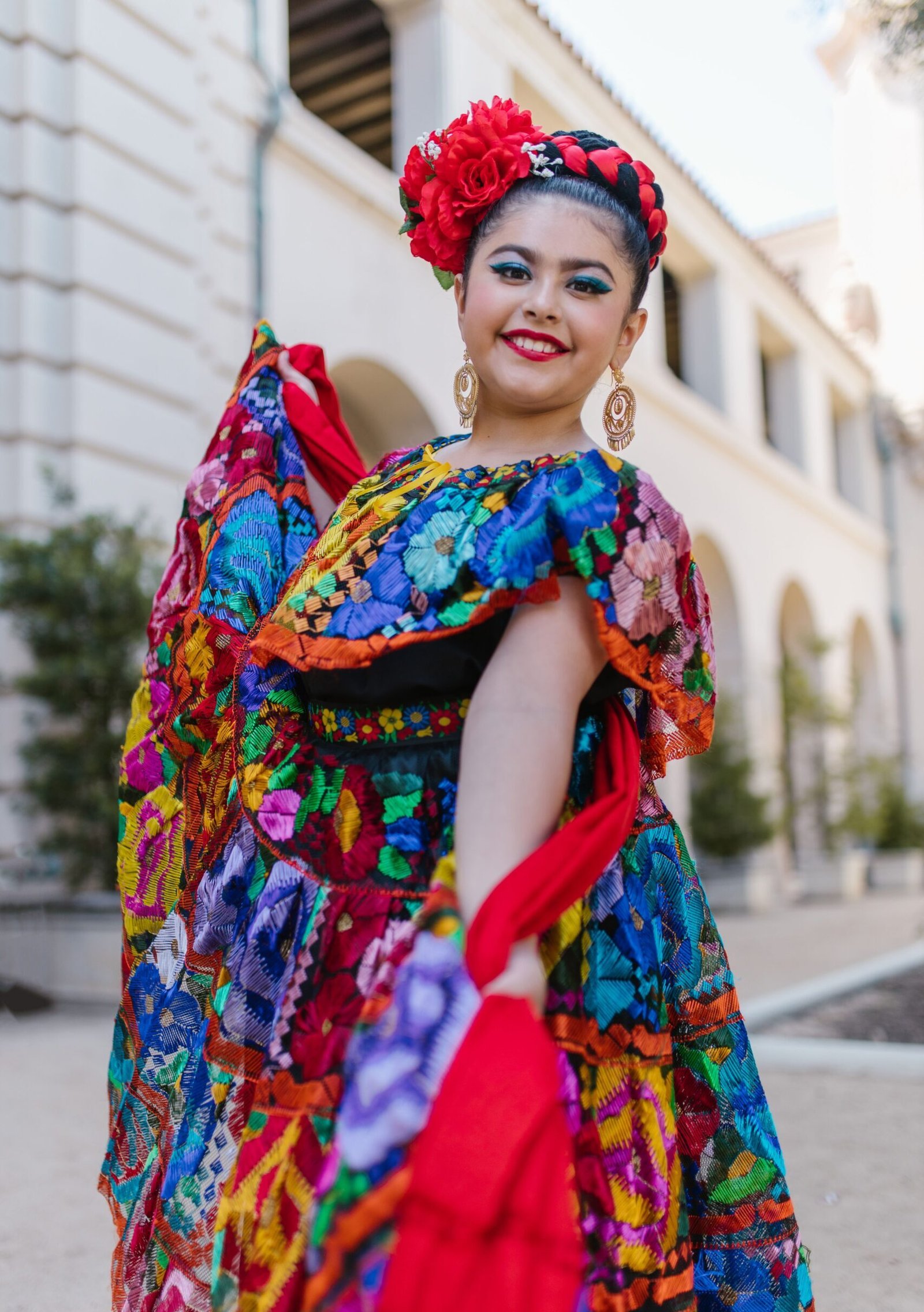 A person wearing a vibrant traditional Mexican Chiapaneco embroidered dress